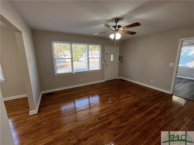 interior space featuring dark wood-type flooring and ceiling fan