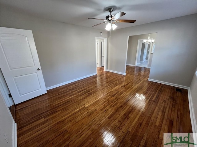 unfurnished room featuring dark hardwood / wood-style floors and ceiling fan with notable chandelier