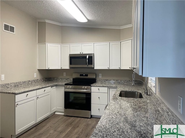 kitchen featuring appliances with stainless steel finishes, sink, white cabinets, and light stone counters