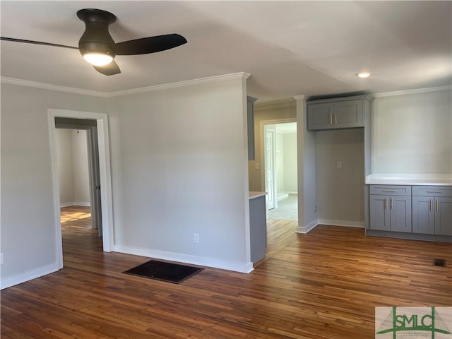 unfurnished room with dark hardwood / wood-style flooring, ornamental molding, and ceiling fan