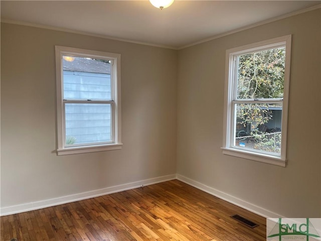 empty room featuring ornamental molding and light wood-type flooring