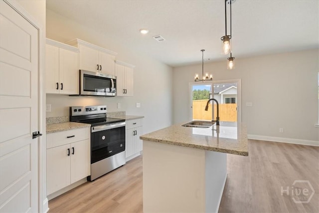 330 Crosswinds Dr, Rincon, GA 31326 - kitchen with stainless steel appliances, a sink, light wood-style floors, an island with sink, and a chandelier