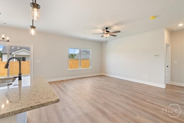 330 Crosswinds Dr, Rincon, GA 31326 - unfurnished living room featuring a sink, light wood-type flooring, baseboards, and ceiling fan