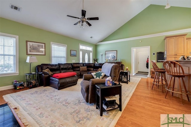 living room with ceiling fan, high vaulted ceiling, and light hardwood / wood-style floors