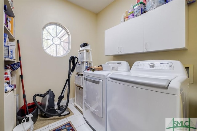 washroom with independent washer and dryer, cabinets, and light tile patterned flooring