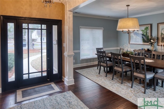 dining area featuring ornamental molding, dark hardwood / wood-style floors, decorative columns, and a notable chandelier