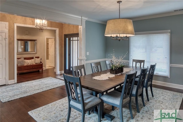 dining space featuring dark hardwood / wood-style flooring, ornamental molding, and an inviting chandelier