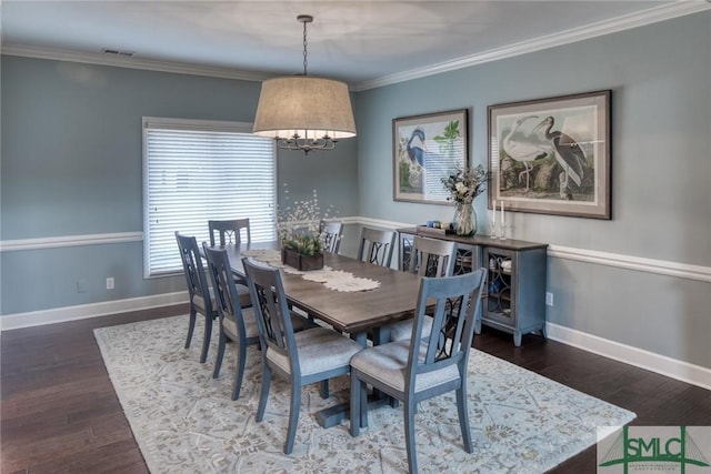 dining room featuring ornamental molding and dark hardwood / wood-style floors