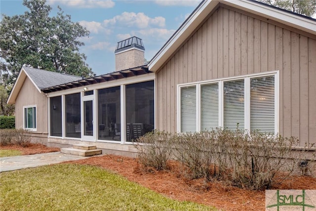 back of house with a yard and a sunroom