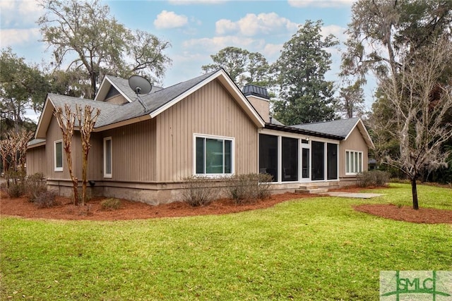 rear view of property with a yard and a sunroom