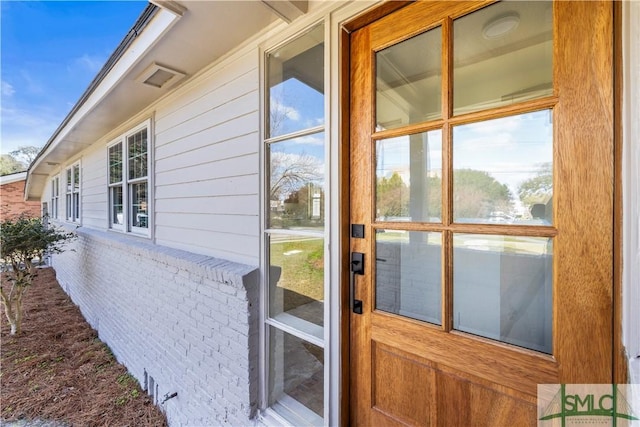 view of exterior entry with brick siding