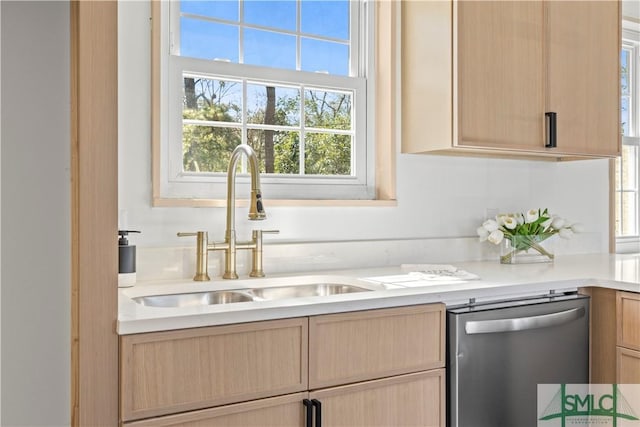 kitchen with a sink, light brown cabinets, light countertops, and dishwasher