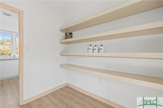 interior space with visible vents, baseboards, and wood finished floors