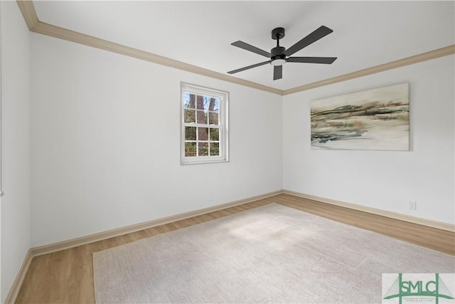 spare room with ornamental molding, wood finished floors, a ceiling fan, and baseboards