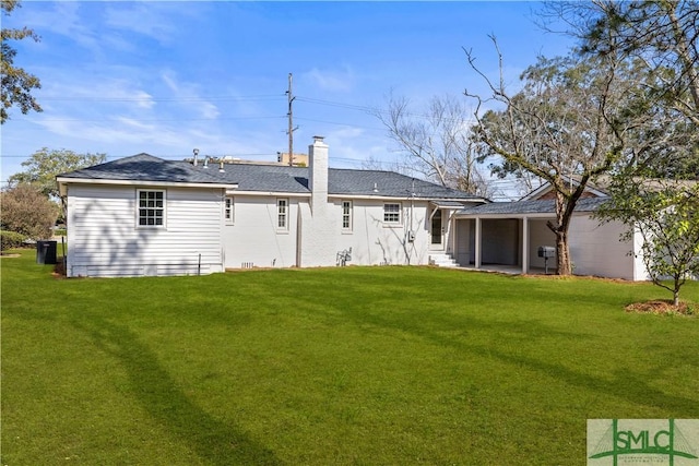 back of property with a yard, a chimney, and central air condition unit