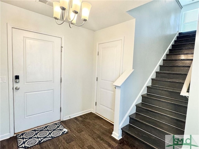 entrance foyer with an inviting chandelier and dark hardwood / wood-style floors