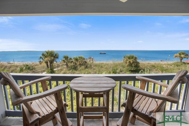 balcony featuring a water view and a beach view