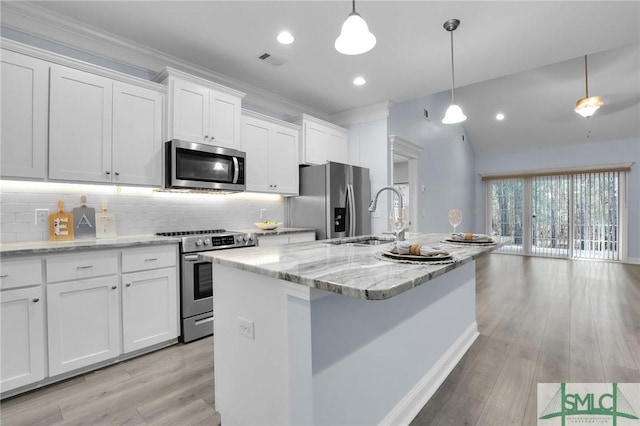 kitchen with white cabinetry, light stone counters, a center island with sink, appliances with stainless steel finishes, and pendant lighting