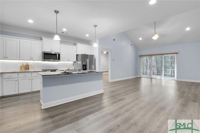 kitchen with stainless steel appliances, hanging light fixtures, a center island with sink, and white cabinets