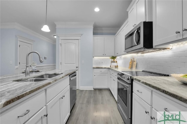 kitchen with sink, crown molding, decorative light fixtures, stainless steel appliances, and white cabinets