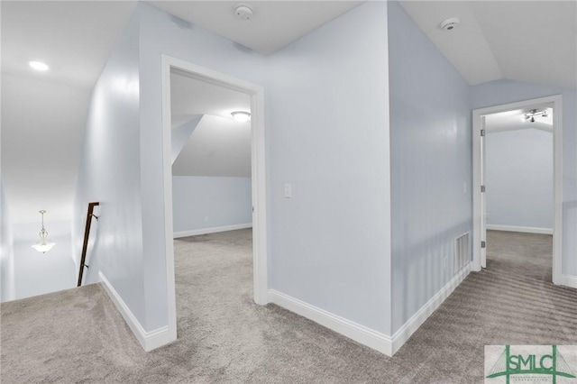 corridor with lofted ceiling and carpet flooring