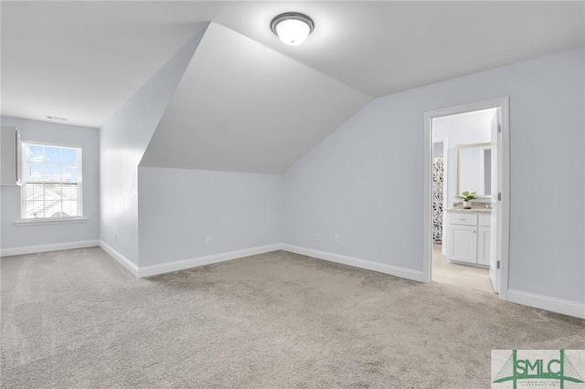 bonus room featuring light colored carpet and lofted ceiling