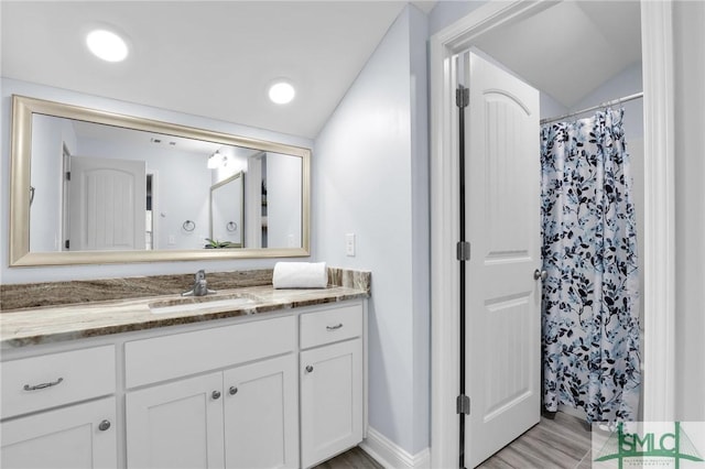 bathroom featuring vanity, lofted ceiling, and a shower with shower curtain