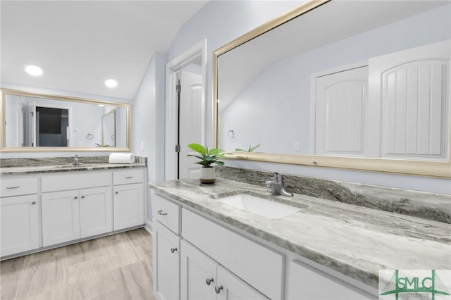 bathroom with vanity, wood-type flooring, and lofted ceiling