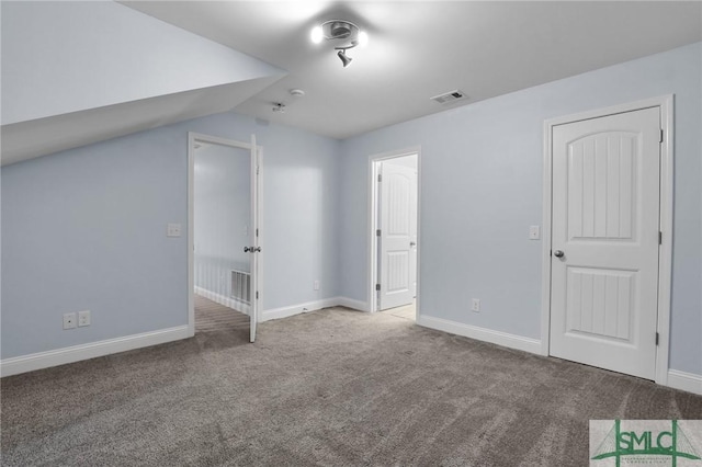 additional living space featuring vaulted ceiling and carpet