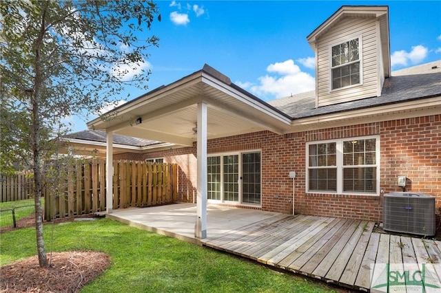 rear view of house with central AC, ceiling fan, a deck, and a lawn