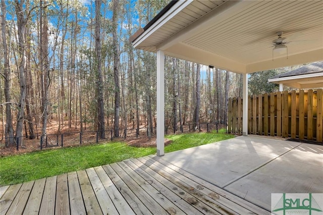 wooden terrace with ceiling fan and a yard