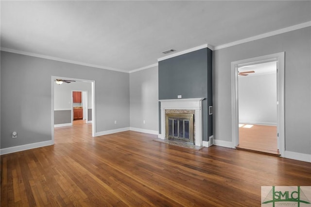 unfurnished living room featuring hardwood / wood-style flooring, ceiling fan, a high end fireplace, and crown molding