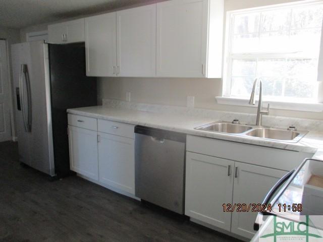 kitchen with stainless steel appliances, white cabinetry, and sink