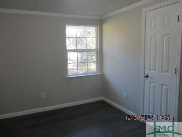 empty room featuring ornamental molding and dark hardwood / wood-style floors