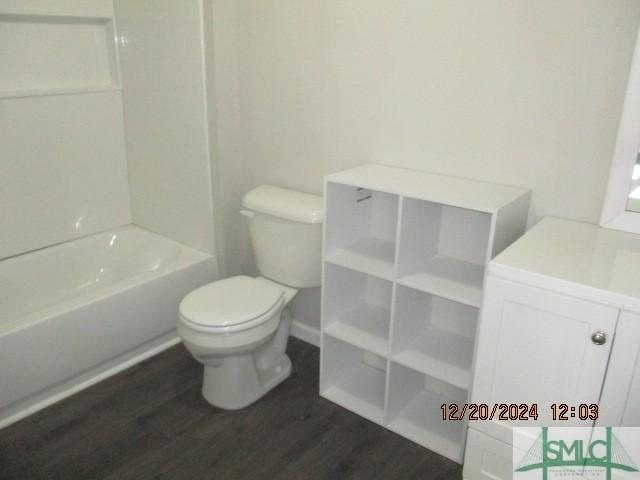 bathroom with hardwood / wood-style flooring, toilet, and shower / bath combination