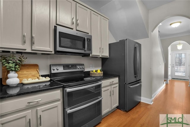 kitchen featuring ornamental molding, appliances with stainless steel finishes, gray cabinets, and light wood-type flooring