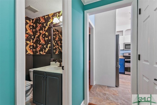 216 Olde Towne Rd, Savannah, GA 31410 - bathroom with wallpapered walls, toilet, vanity, and stone finish floors