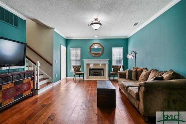 216 Olde Towne Rd, Savannah, GA 31410 - living room featuring stairs, dark wood-style flooring, a fireplace with flush hearth, a textured ceiling, and crown molding