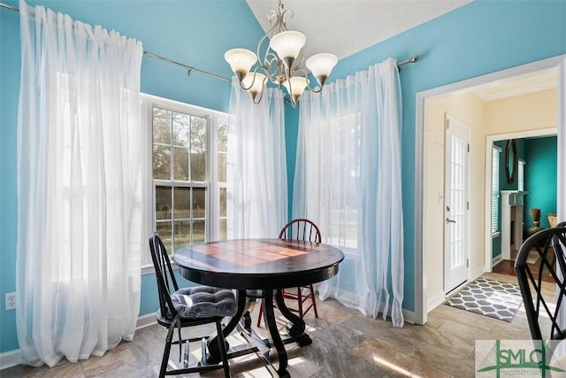 216 Olde Towne Rd, Savannah, GA 31410 - dining space featuring stone finish flooring, a chandelier, baseboards, and vaulted ceiling