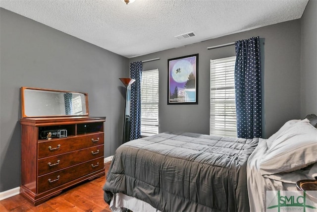 216 Olde Towne Rd, Savannah, GA 31410 - bedroom with wood finished floors, a textured ceiling, and baseboards