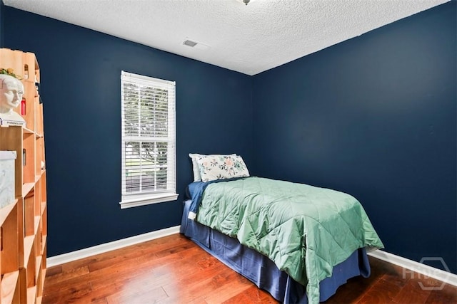 216 Olde Towne Rd, Savannah, GA 31410 - bedroom with a textured ceiling, wood finished floors, and baseboards