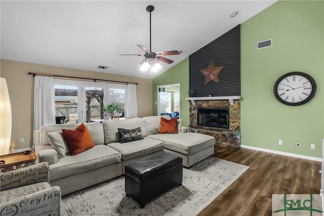 living room featuring hardwood / wood-style floors, a stone fireplace, high vaulted ceiling, and ceiling fan