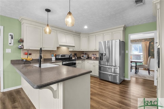 kitchen featuring sink, white cabinetry, decorative light fixtures, kitchen peninsula, and stainless steel appliances