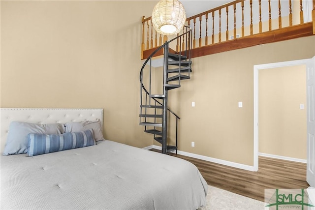 bedroom featuring wood-type flooring and a chandelier