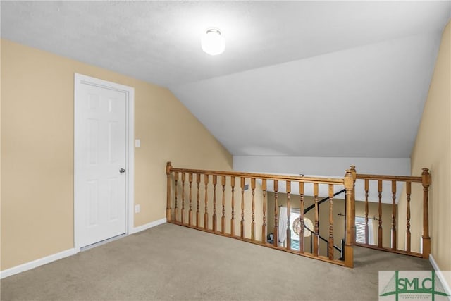 bonus room with vaulted ceiling and carpet