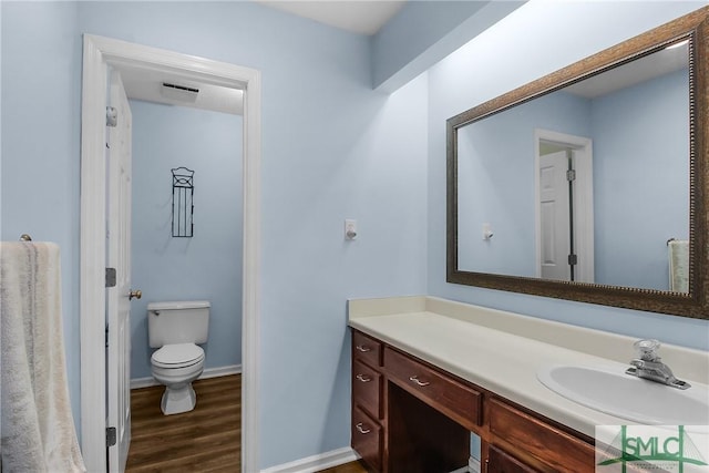 bathroom featuring vanity, hardwood / wood-style flooring, and toilet