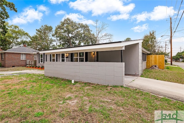 ranch-style home featuring a carport and a front lawn