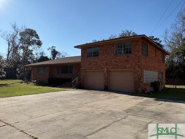 view of front of house with a garage and a front lawn