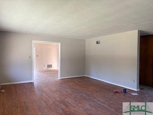 unfurnished room with dark wood-type flooring