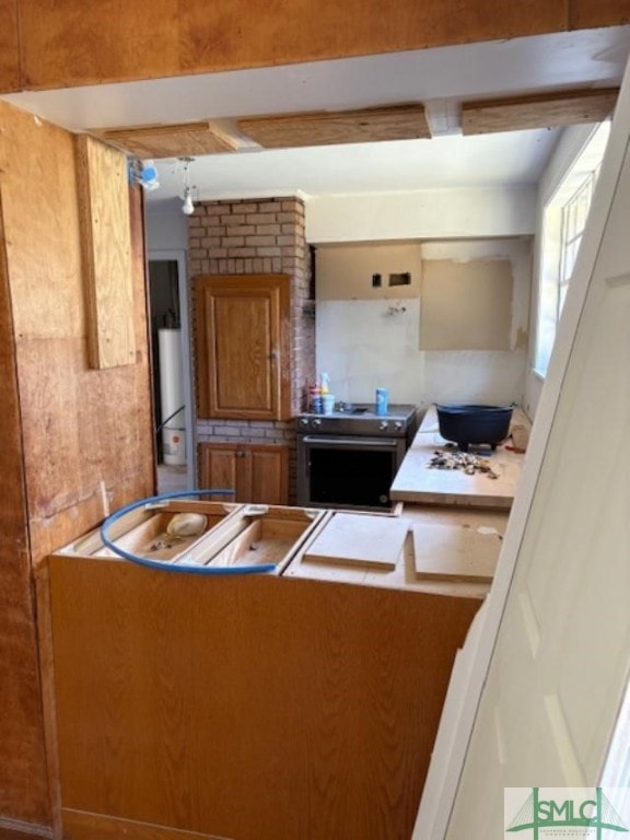 kitchen with electric range, beamed ceiling, and refrigerator